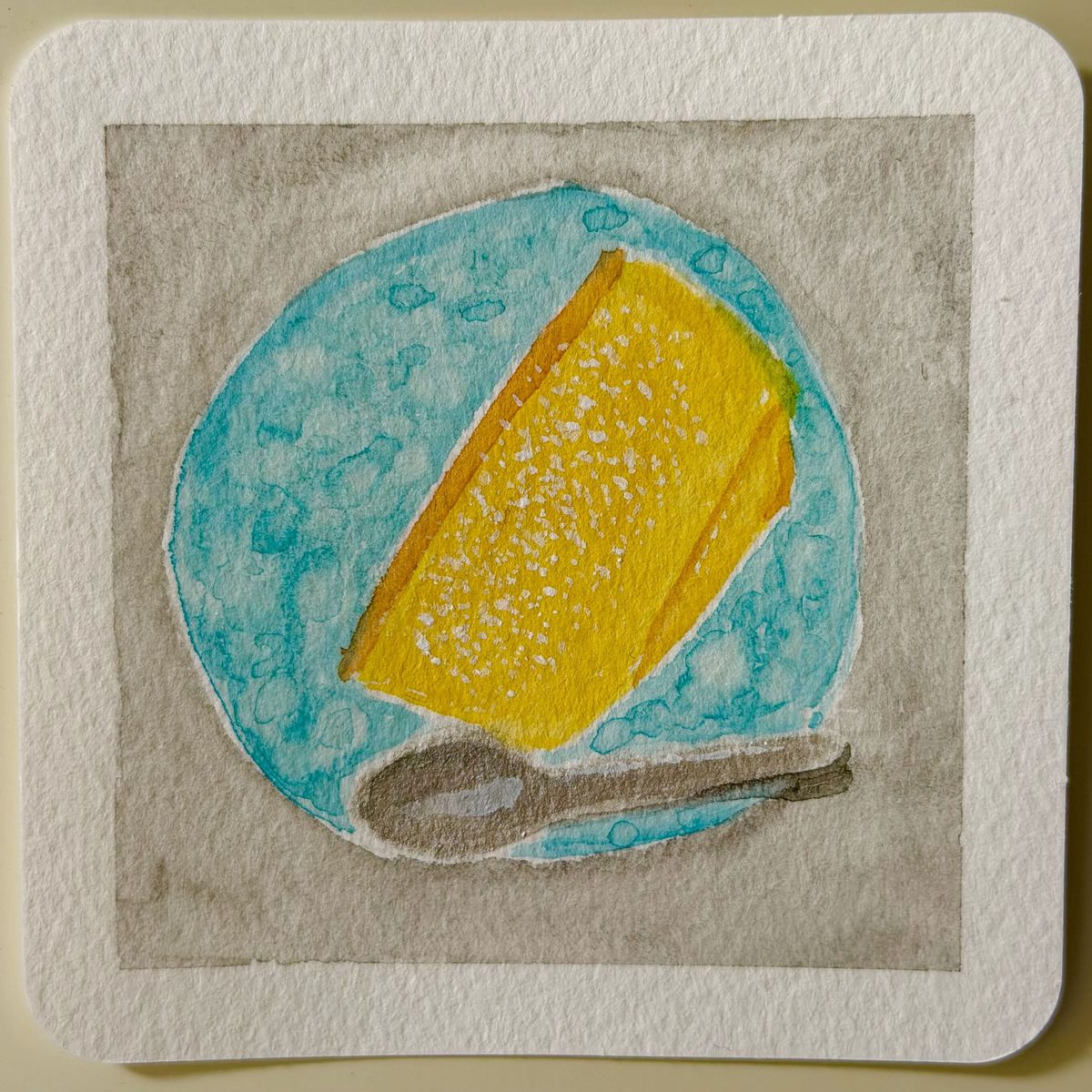 水色のお皿にのった黄色いケーキの水彩イラスト